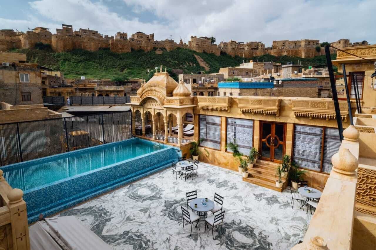 A rooftop pool area with a view of a historic fort in the background.