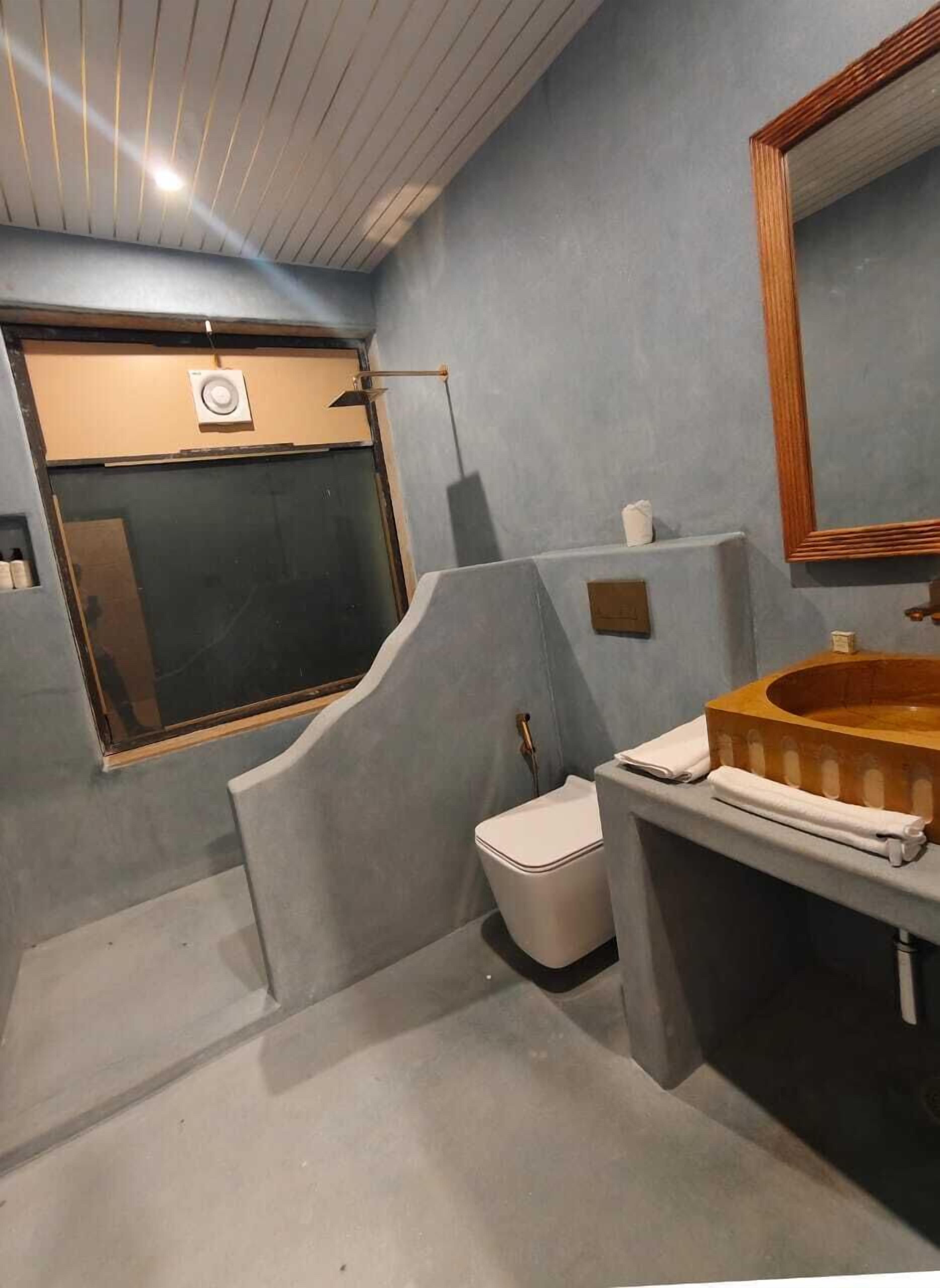 Un baño pequeño con inodoro, lavamanos y espejo.