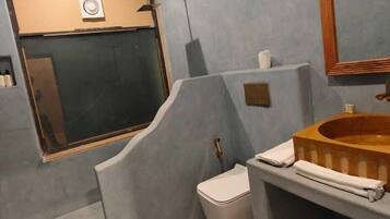 Un baño pequeño con inodoro, lavamanos y espejo.