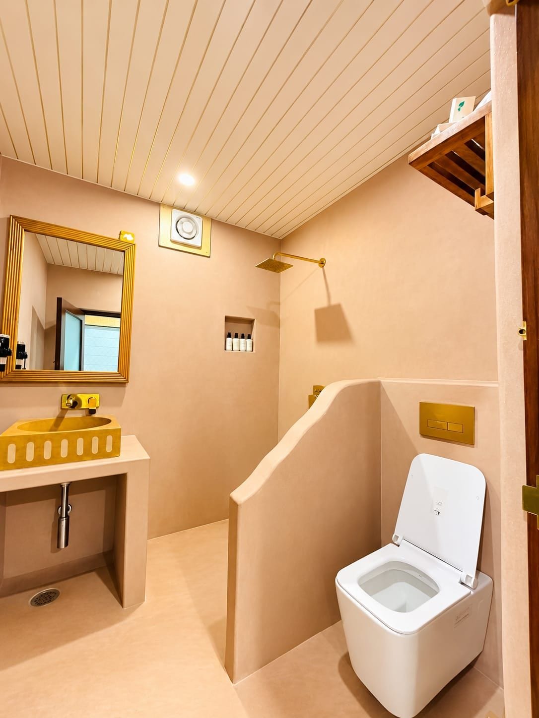 A modern bathroom with a toilet, sink, and shower.