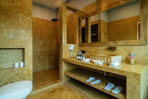 Un baño con lavamanos de mármol, un espejo, una ducha y un inodoro.