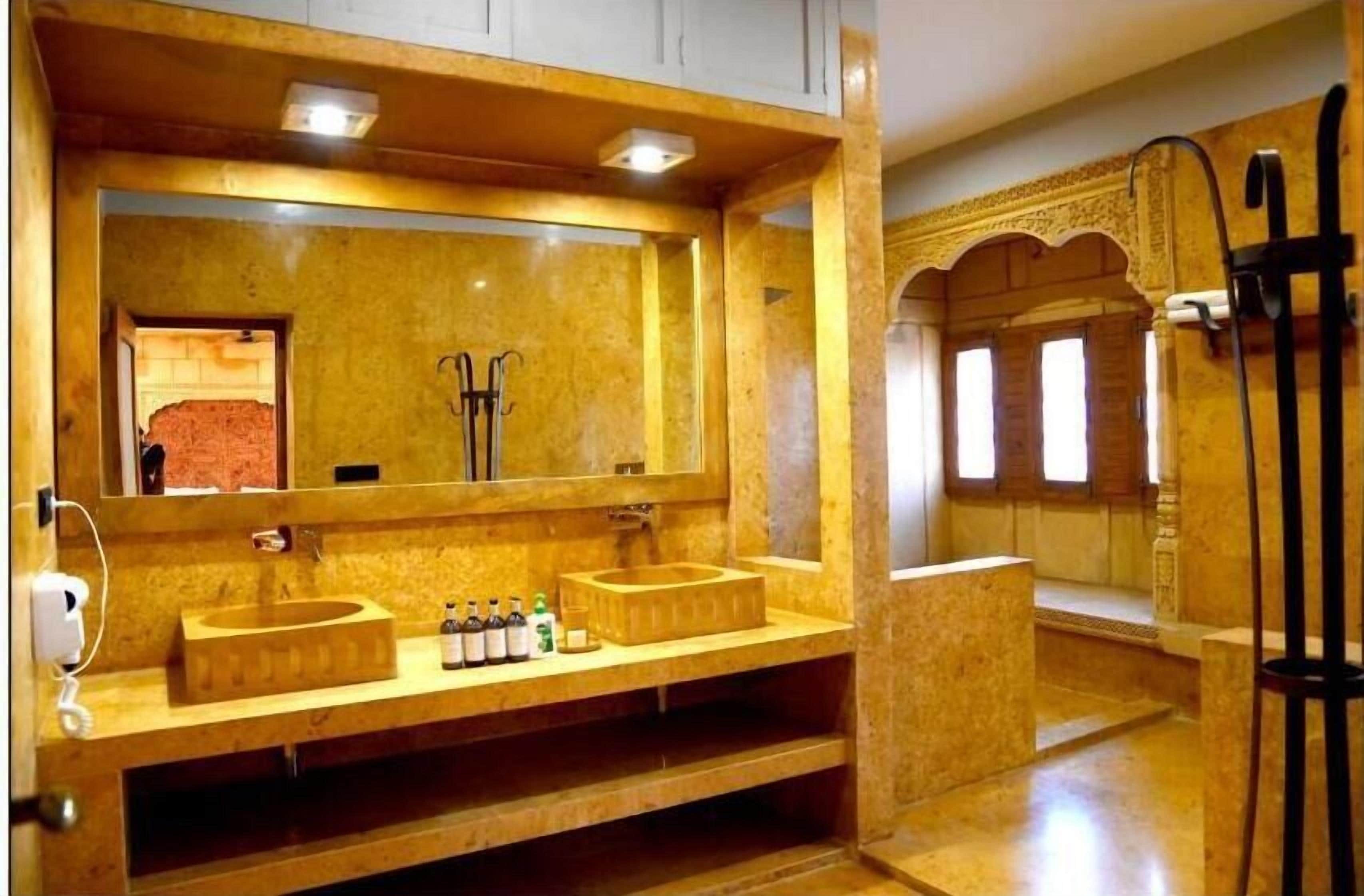 A bathroom with a large mirror, two sinks, and a shower area.