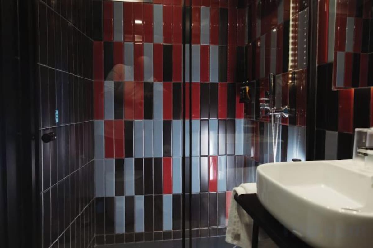 Badkamer | Een douche, een regendouche, een haardroger, pantoffels
