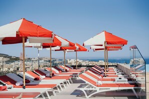 季节性开放的室外游泳池，10:00 至 19:00 开放，池畔遮阳伞，日光浴躺椅