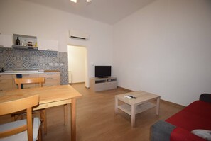 A compact living space with a kitchen, dining area, and a TV.