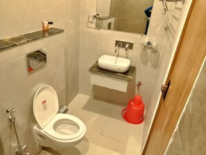 Une petite salle de bain avec des toilettes, un lavabo et un miroir.