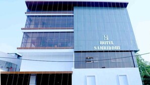 A modern hotel building with a prominent sign reading "HOTEL SAMRIDDHI".
