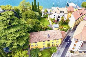 Vue aérienne d’un quartier résidentiel, avec un bâtiment jaune, une route et une étendue d’eau en arrière-plan.