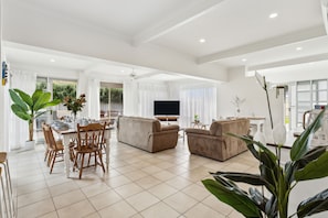 A spacious living area with a dining table, sofas, and a flat-screen TV. - Rye Beach Chalet - Downstairs Only (Rye)