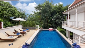 A swimming pool with lounge chairs and umbrellas, surrounded by lush greenery. - Katamanda 3 Bed Tropical Villa B3 Near Kata Beach (Karon)