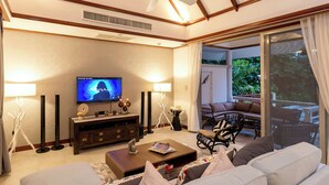 A living room with a television, sofa, coffee table, and a ceiling fan. - Katamanda 3 Bed Tropical Villa B3 Near Kata Beach (Karon)