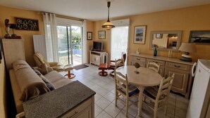 Un espacio habitable compacto con kitchenette, comedor y balcón con vistas.