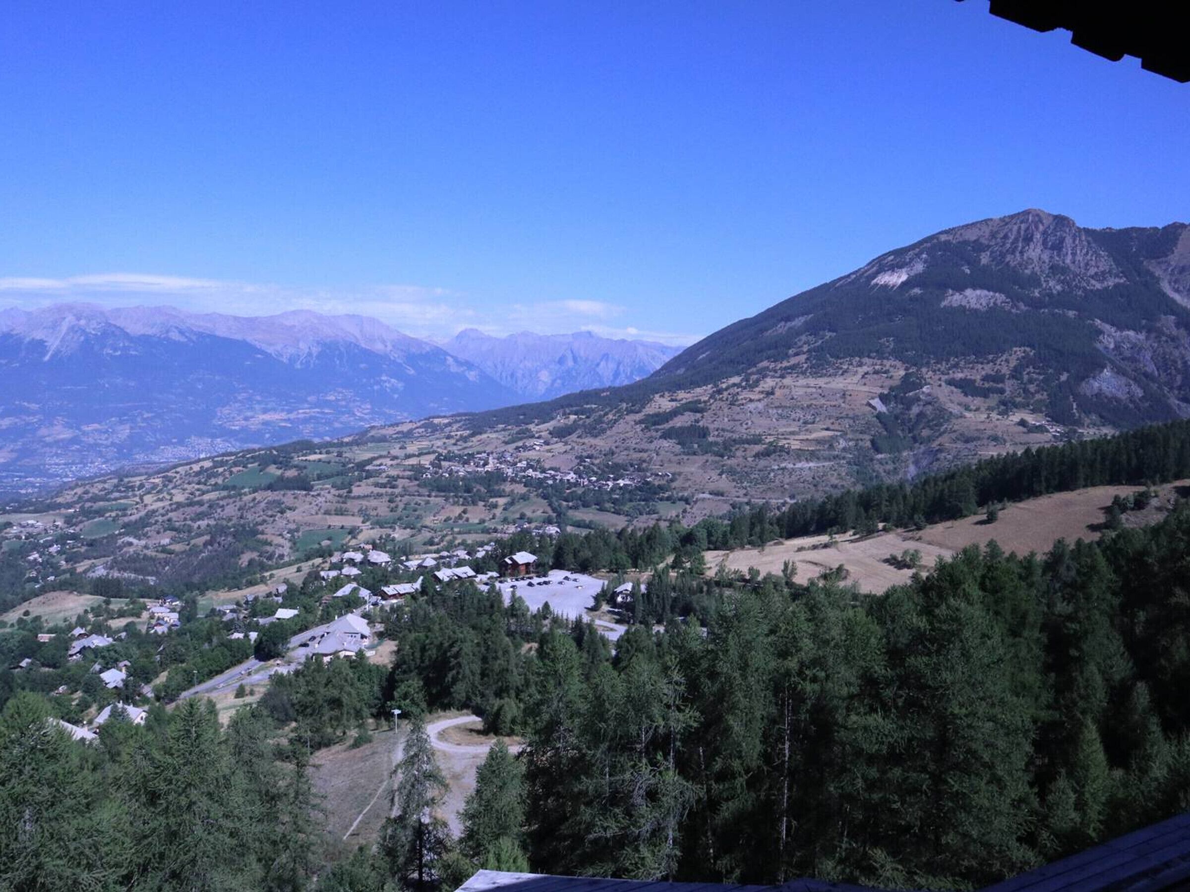 A mountainous landscape with a small village nestled among trees.