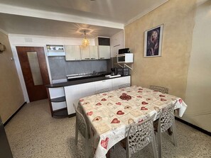 A compact kitchen with a dining area, a microwave, and a sink.