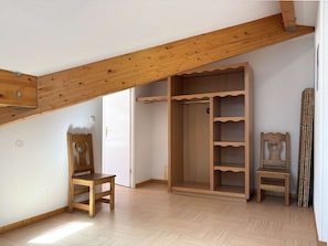 A room with a wooden ceiling, a wooden wardrobe, two wooden chairs, and a wooden table. - Spacious Duplex for 8 with Balcony, Pool Access, and Ski-In/Ski-Out at Les Orres 1800 (Les Orres)
