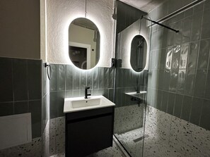 Apartamento de diseño | Baño | Ducha, cabezal de ducha tipo lluvia, secador de pelo y zapatillas