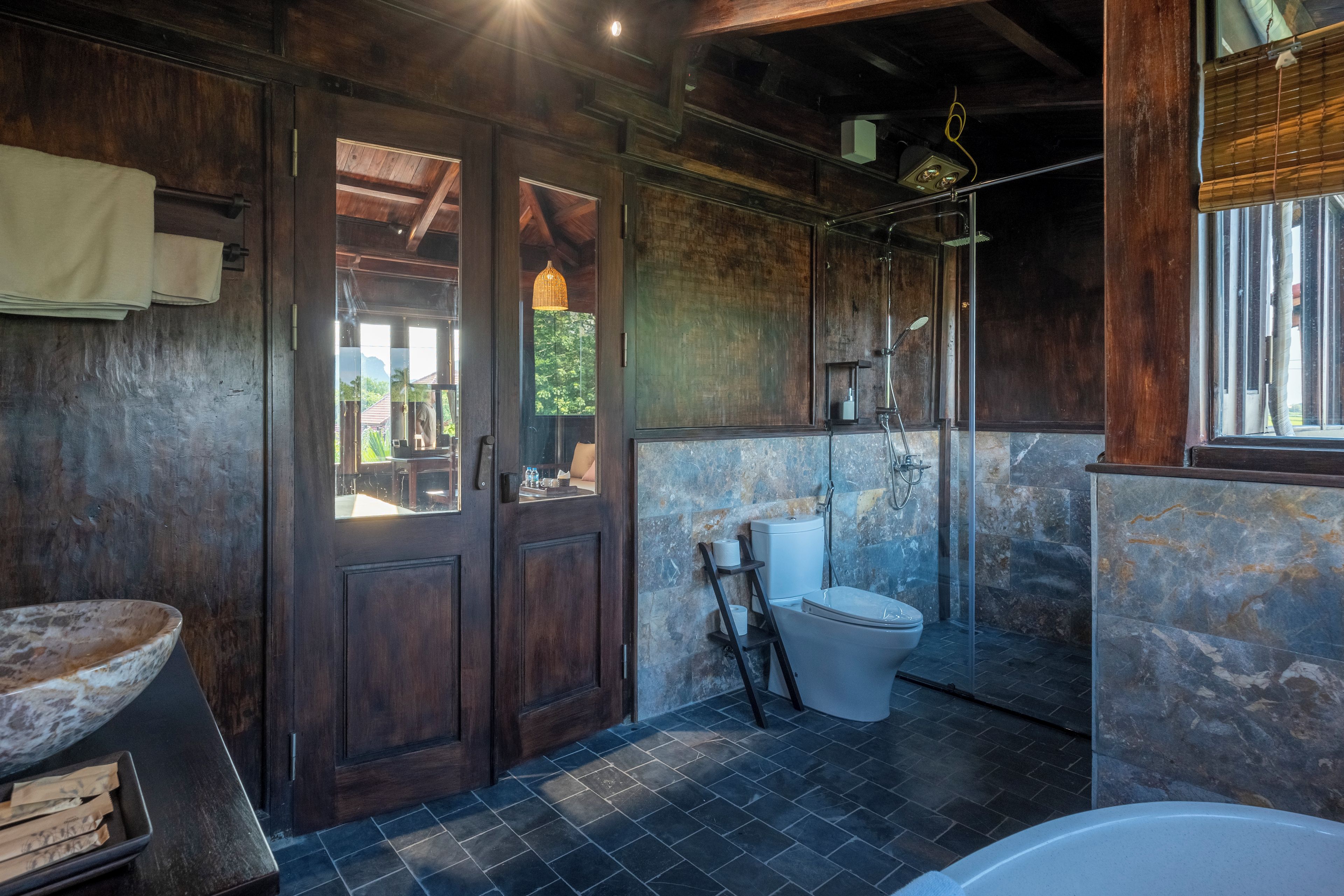 Un bagno con porta in legno, un water, una doccia e una vasca da bagno.