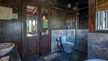 Un bagno con porta in legno, un water, una doccia e una vasca da bagno.