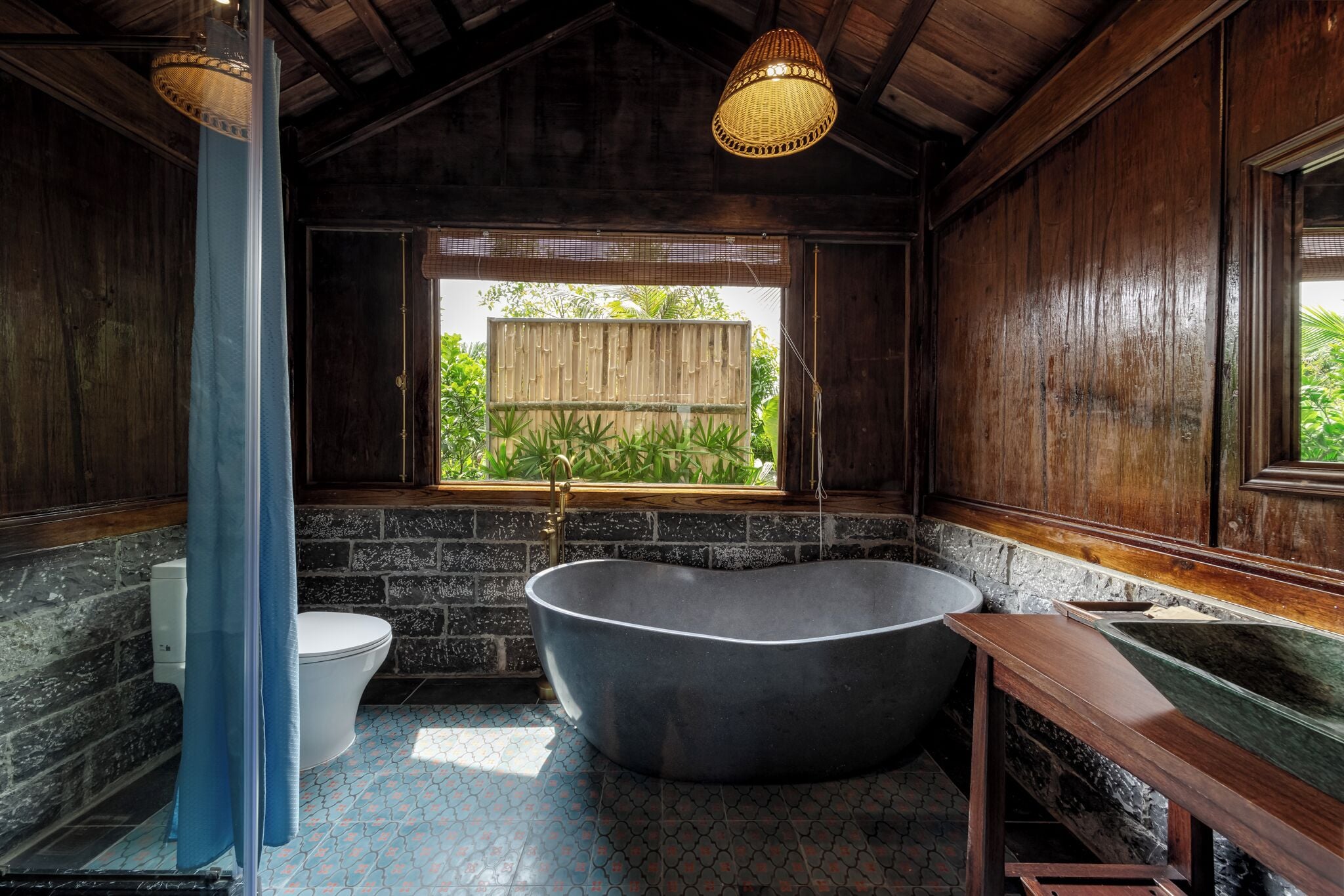 Een badkamer met een vrijstaand bad, een toilet en een wastafel.