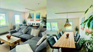 Una sala de estar moderna con un sofá gris, una mesa de centro de madera y un comedor con una mesa de madera y sillas negras.