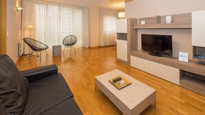 A modern living room with a sofa, two chairs, a coffee table, a fireplace, and a television. - Espacioso Apartamento en Yamaguchi (Pamplona)