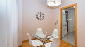 A dining area with a round glass table and four white chairs. - Espacioso Apartamento en Yamaguchi (Pamplona)