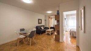 Ein geräumiger Wohnbereich mit Esstisch, Stühlen, Sofas und Holzboden.