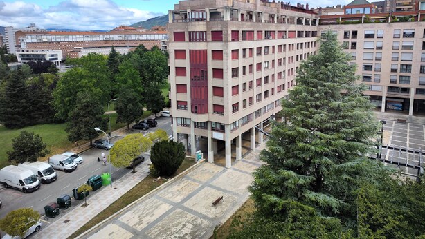 A multi-story building with a central courtyard, surrounded by trees and parked vehicles. - Para 4, el Apartamento Idóneo (Pamplona)