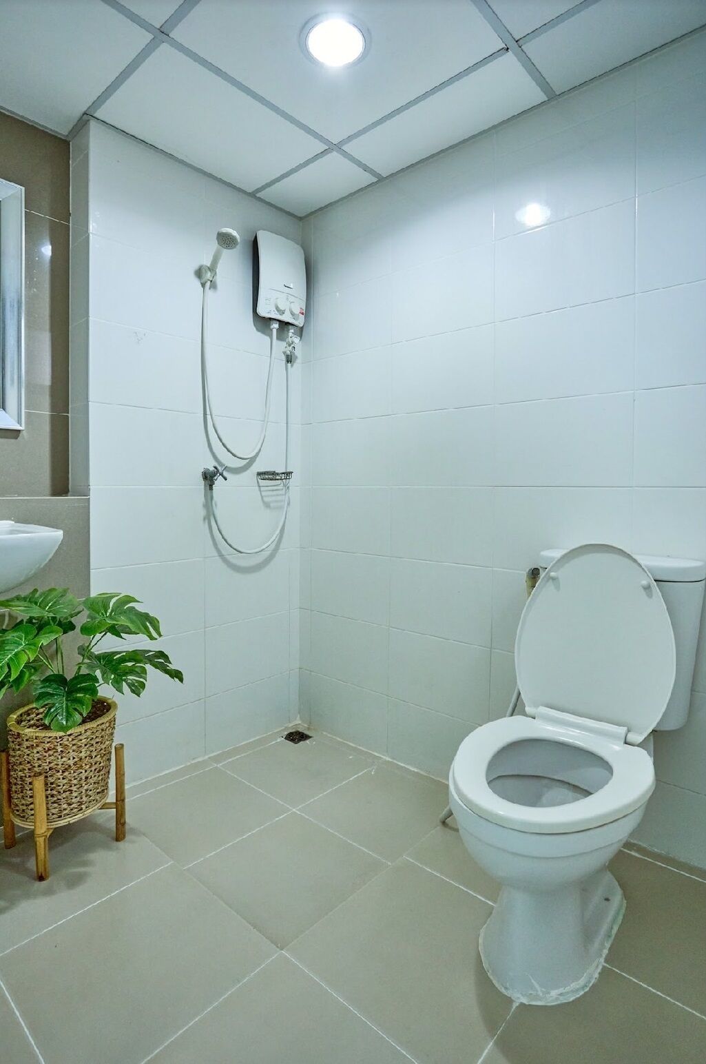 A bathroom with a toilet, a shower, and a sink.