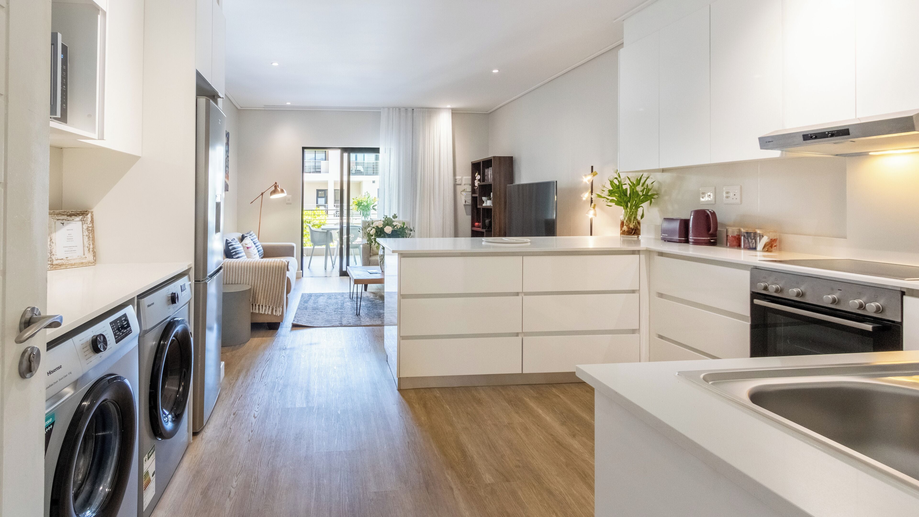 Una cocina moderna con electrodomésticos integrados, un comedor con vistas y un cuarto de lavado.