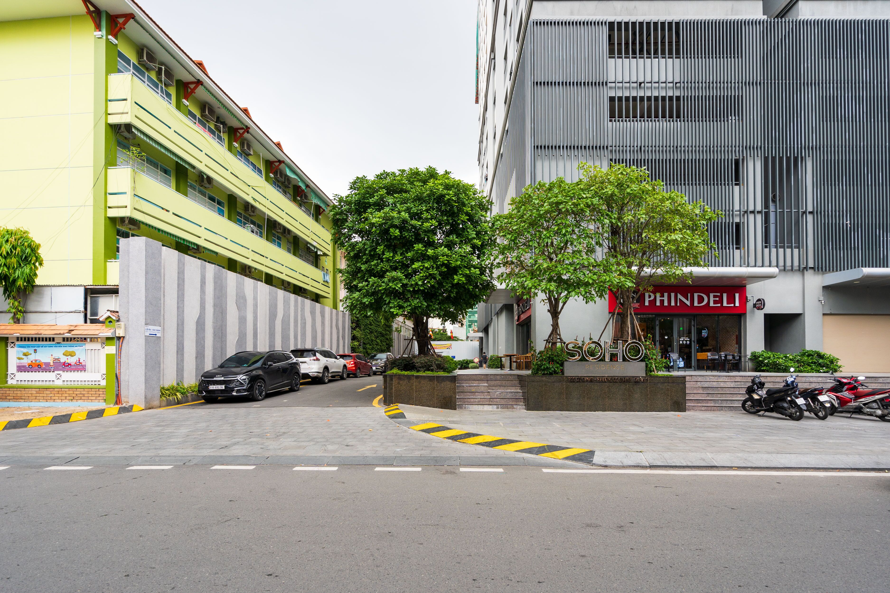 A street view with a building labeled "PHINDELI" and a tree in the foreground.