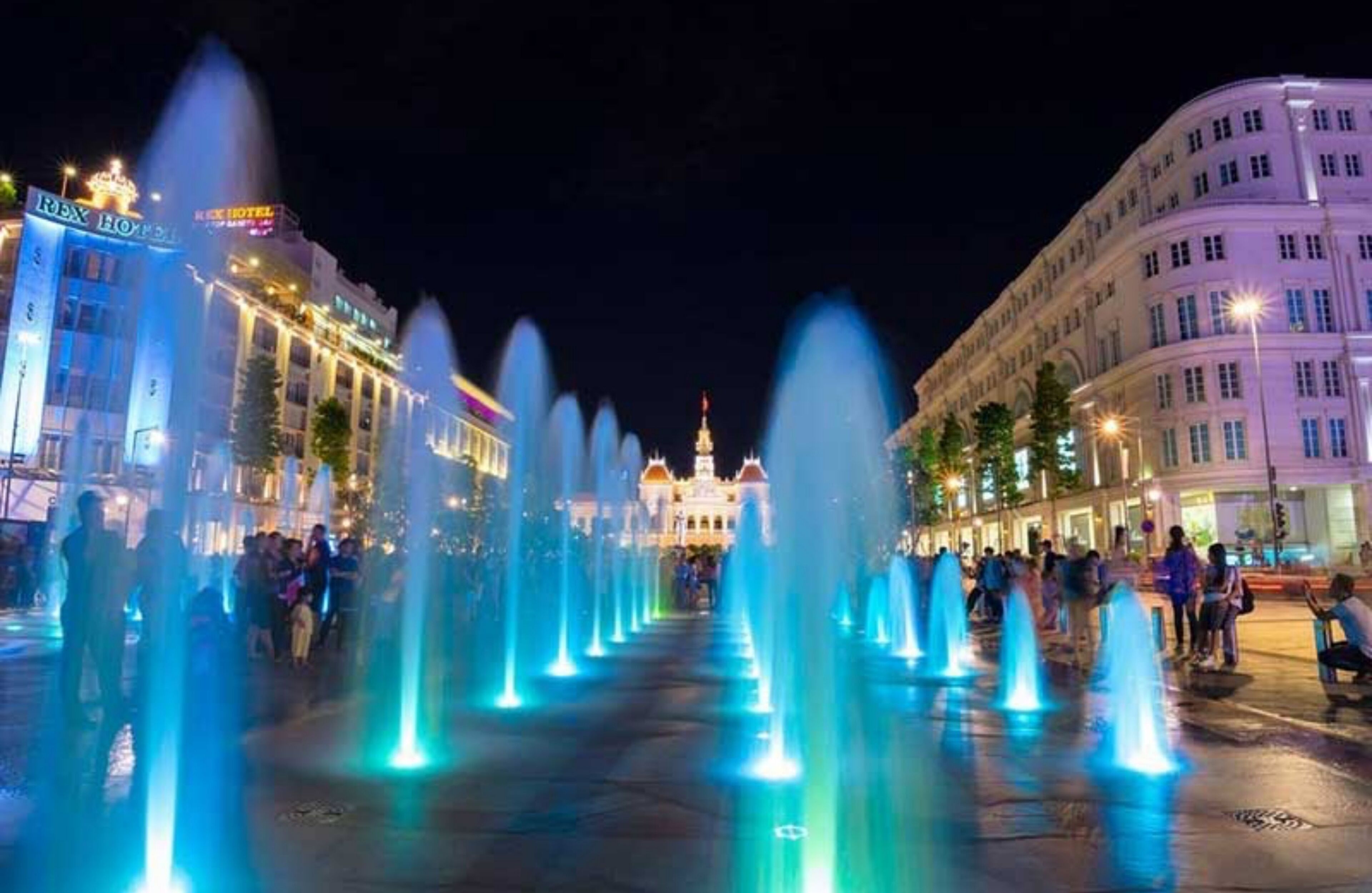 Un hotel con una fontana in primo piano e un edificio imponente sullo sfondo.