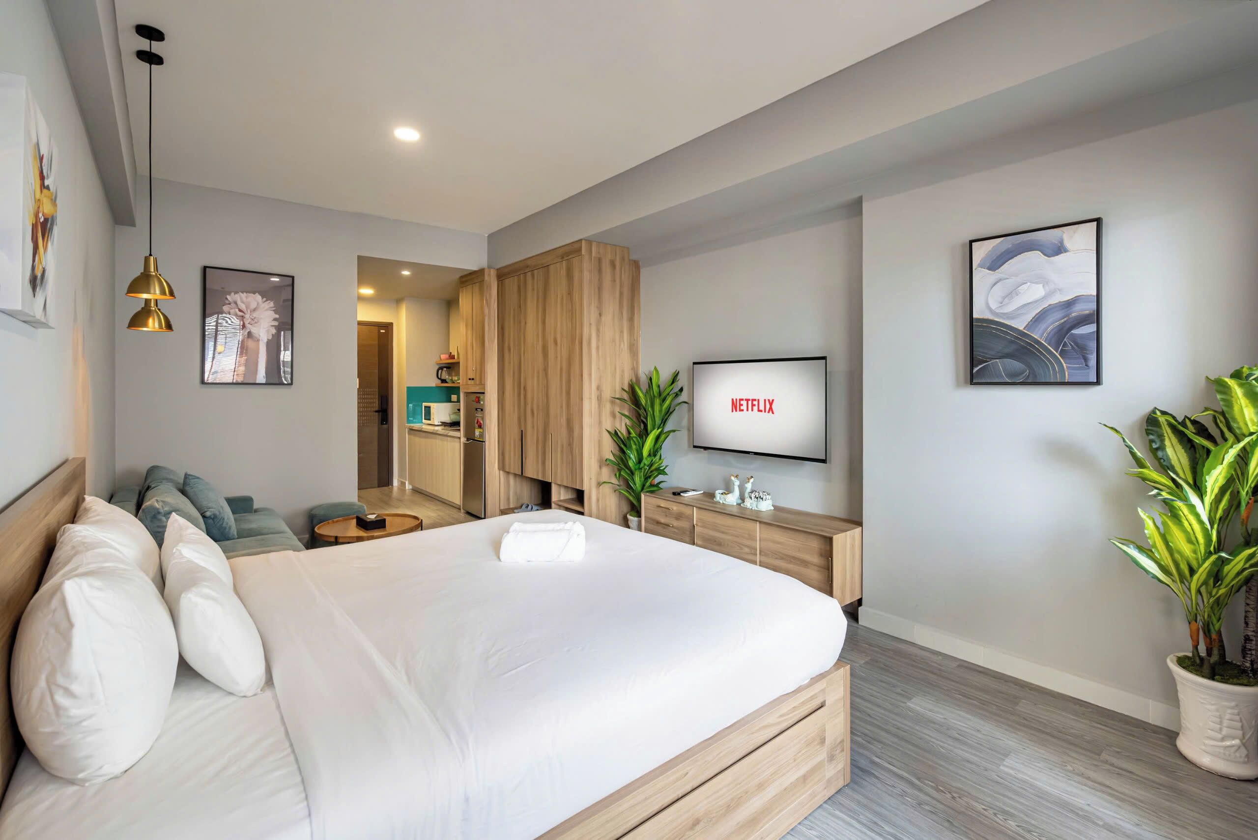 Une chambre d’hôtel moderne équipée d’un grand lit, d’une télévision, d’un bureau et d’un coin salon.