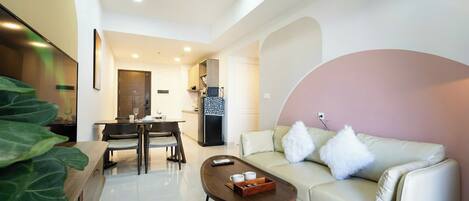 A modern living room with a sofa, coffee table, and dining area.
