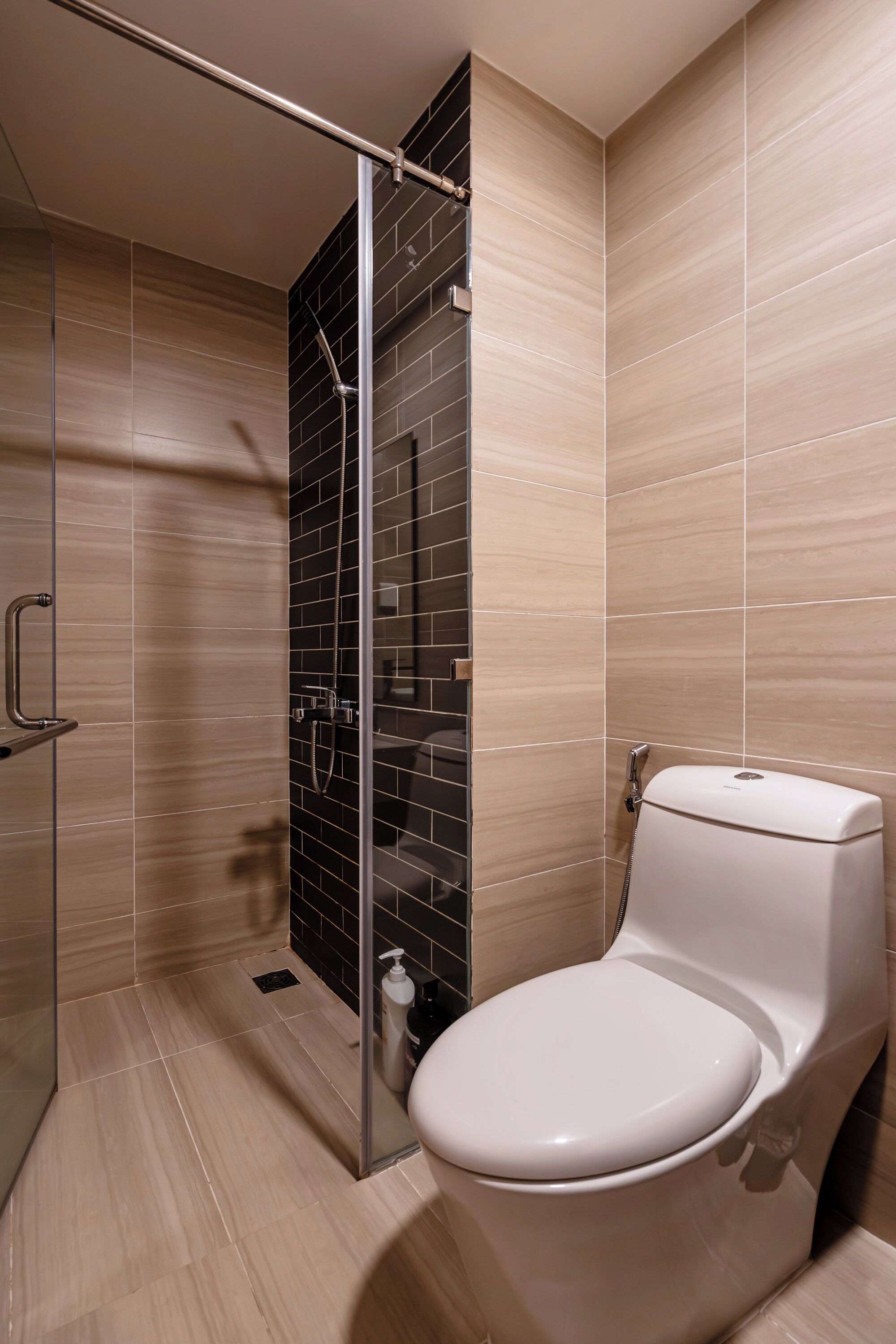 A modern bathroom with a glass shower enclosure, a toilet, and a sink.