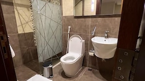 A modern bathroom with a shower, toilet, and sink. - Wow Grand Serviced Apartments (Jeddah)