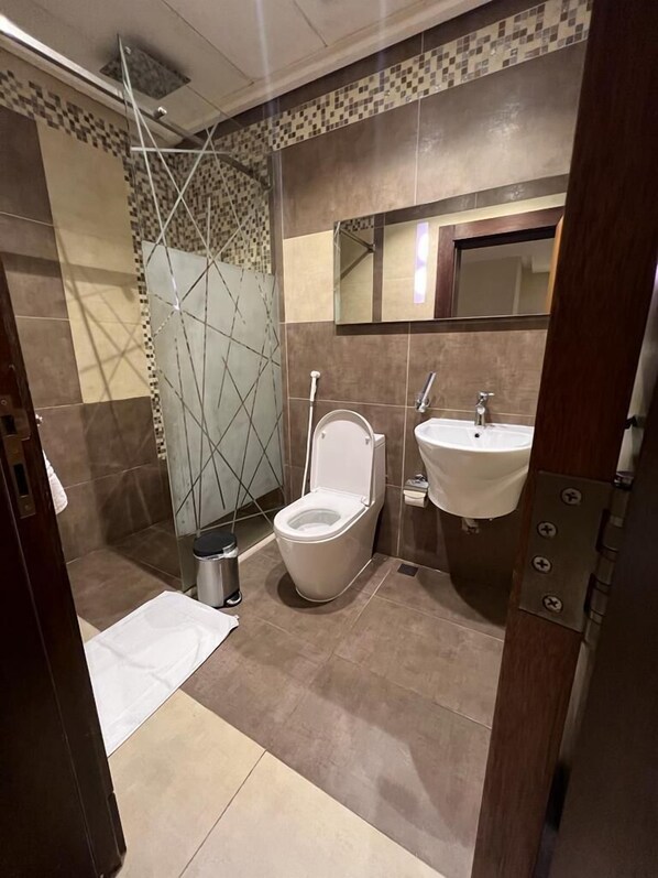 Un baño moderno con ducha, inodoro y lavamanos.