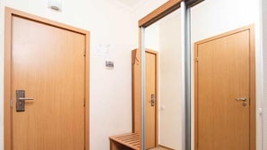 Um corredor com portas de madeira e um espelho grande.
