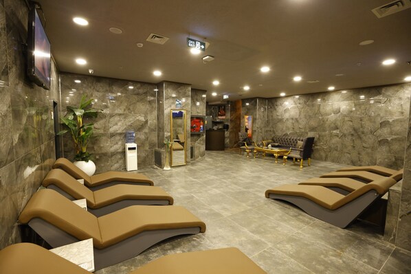 A spa area with massage chairs, a reception desk, and a seating area with a plant.