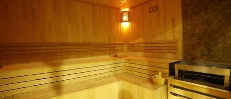 Una sauna con bancos de madera y una pared de piedra.