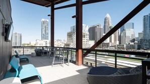 A rooftop terrace with seating, a view of the city skyline, and a clear sky. - Luxury Serviced Apartment in Uptown CLT (Charlotte)