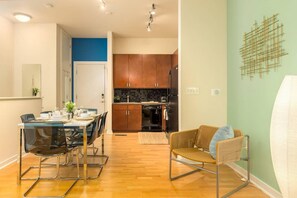 A modern kitchen with wooden cabinets and a black refrigerator. - 2 Bedroom Hip Apartment, Free Parking & Wifi (Charlotte)