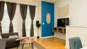 A modern living room with a sofa, coffee table, and TV stand. - 2 Bedroom Hip Apartment, Free Parking & Wifi (Charlotte)