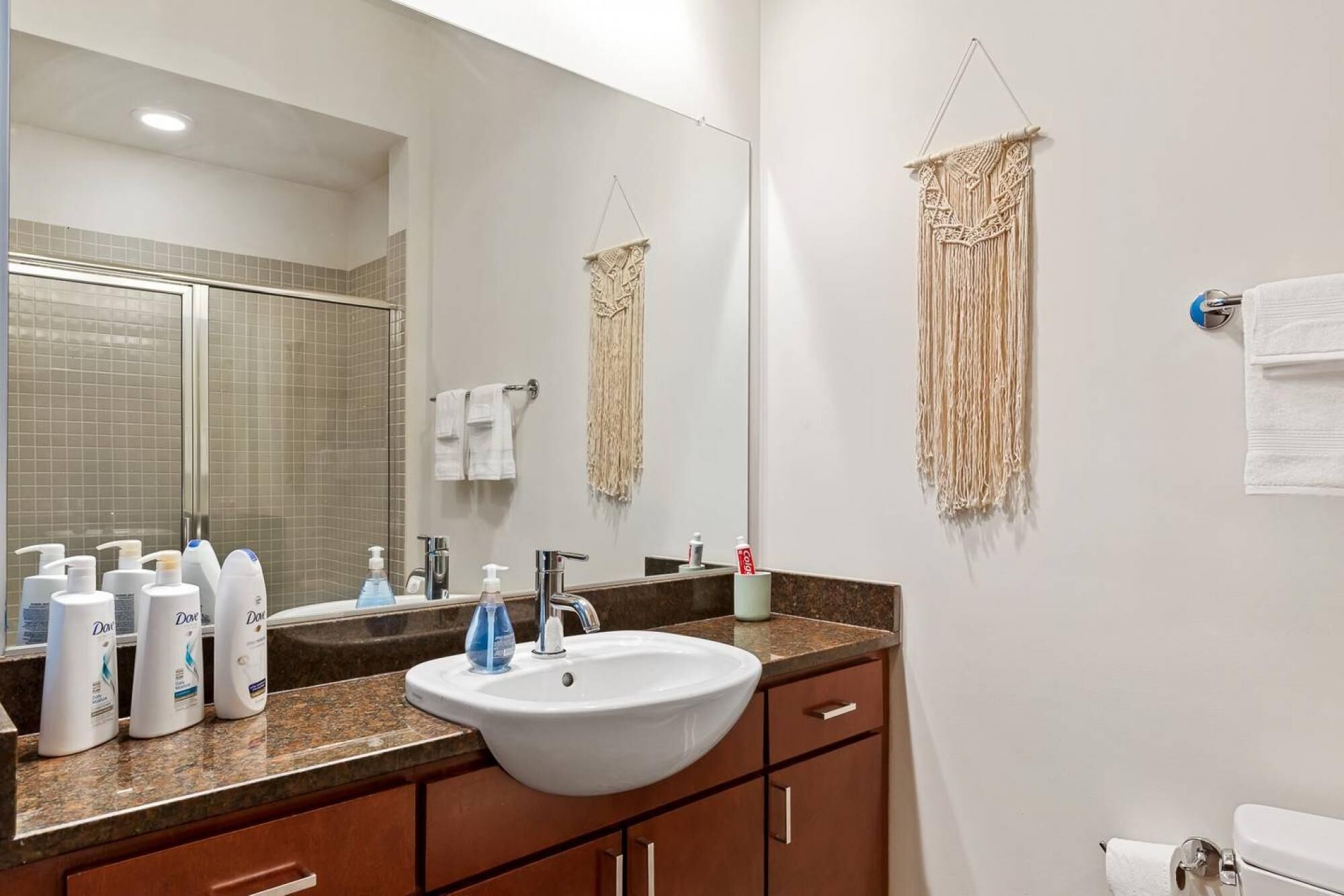 A bathroom with a sink, mirror, and toiletries.