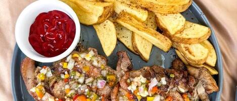A plate with steak, fries, and a hot dog.
