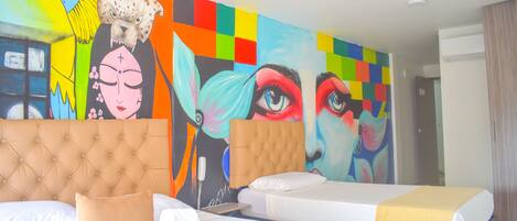 Una habitación de hotel con dos camas, un mural grande y colorido en la pared y un diseño moderno.