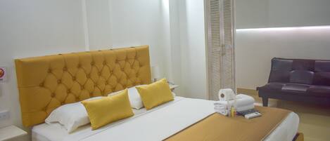 Une chambre d’hôtel avec un grand lit, un canapé et une table de chevet.