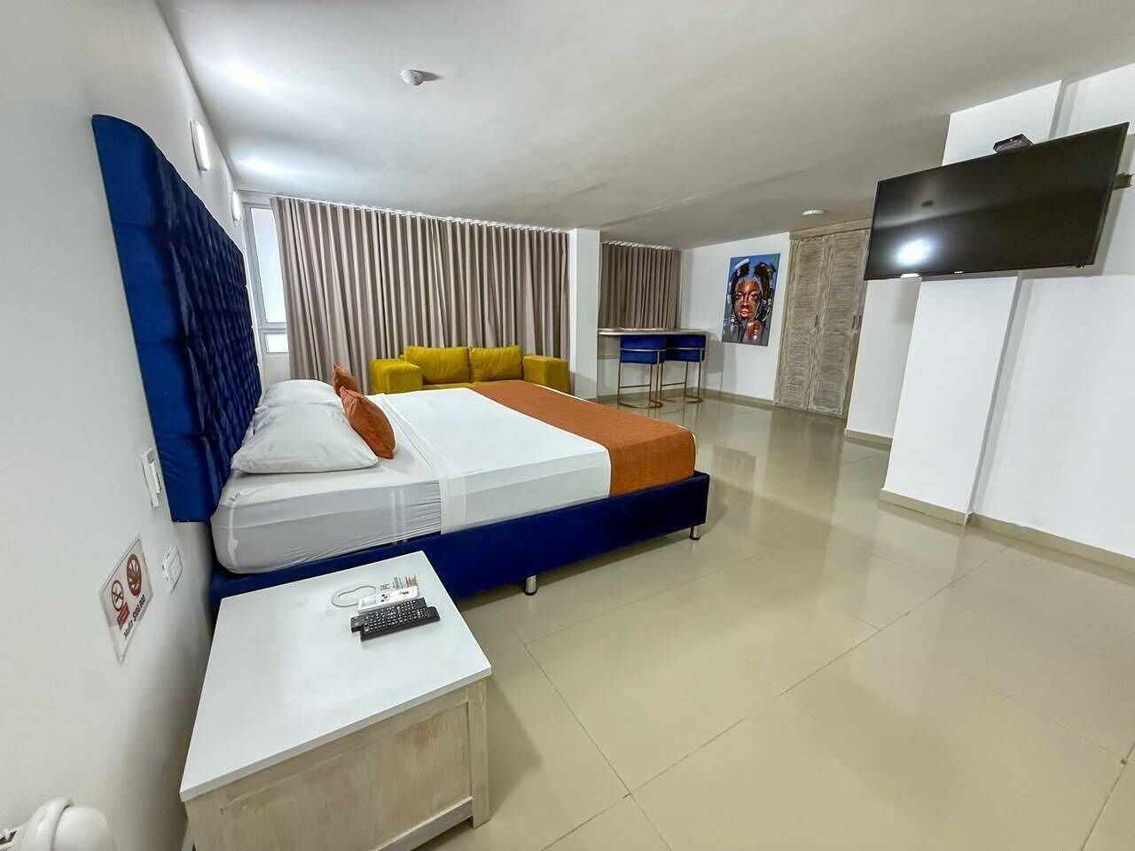 A hotel room with a bed, a TV, a desk, and a chair.
