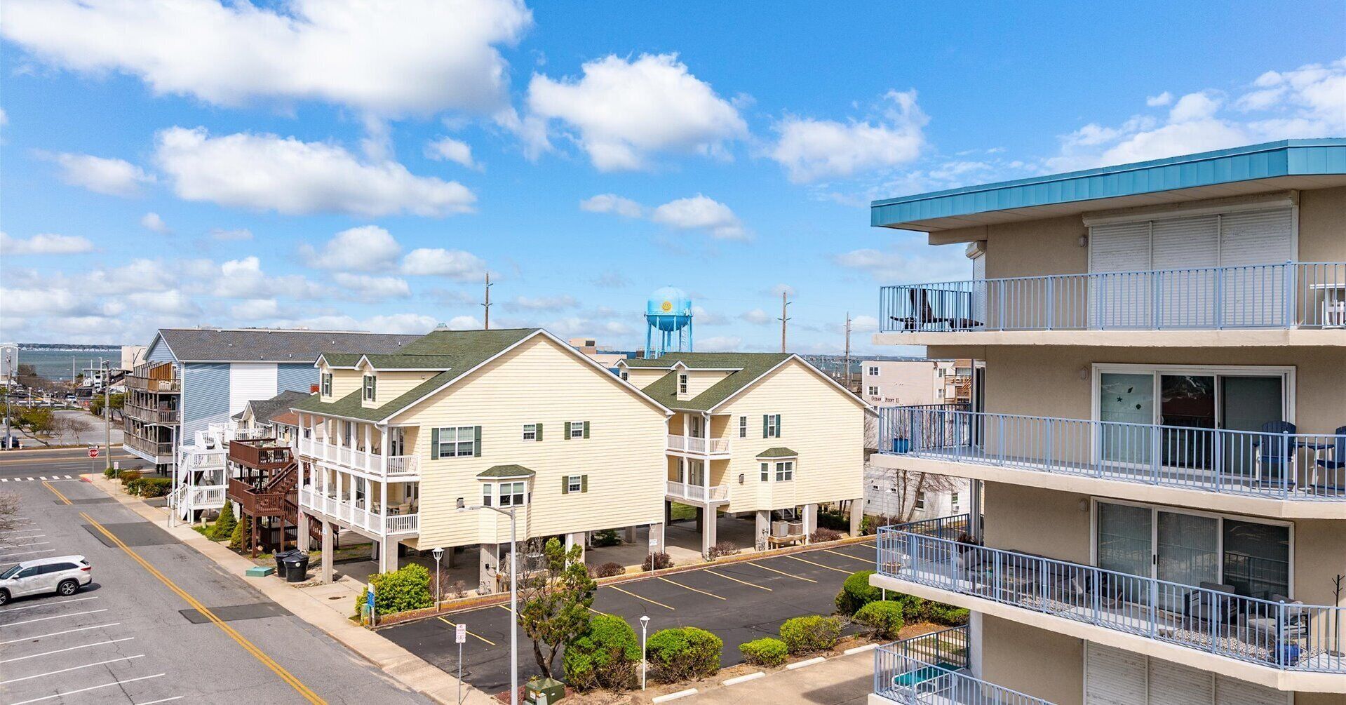 A coastal hotel with multiple-story buildings, balconies, and a parking lot.