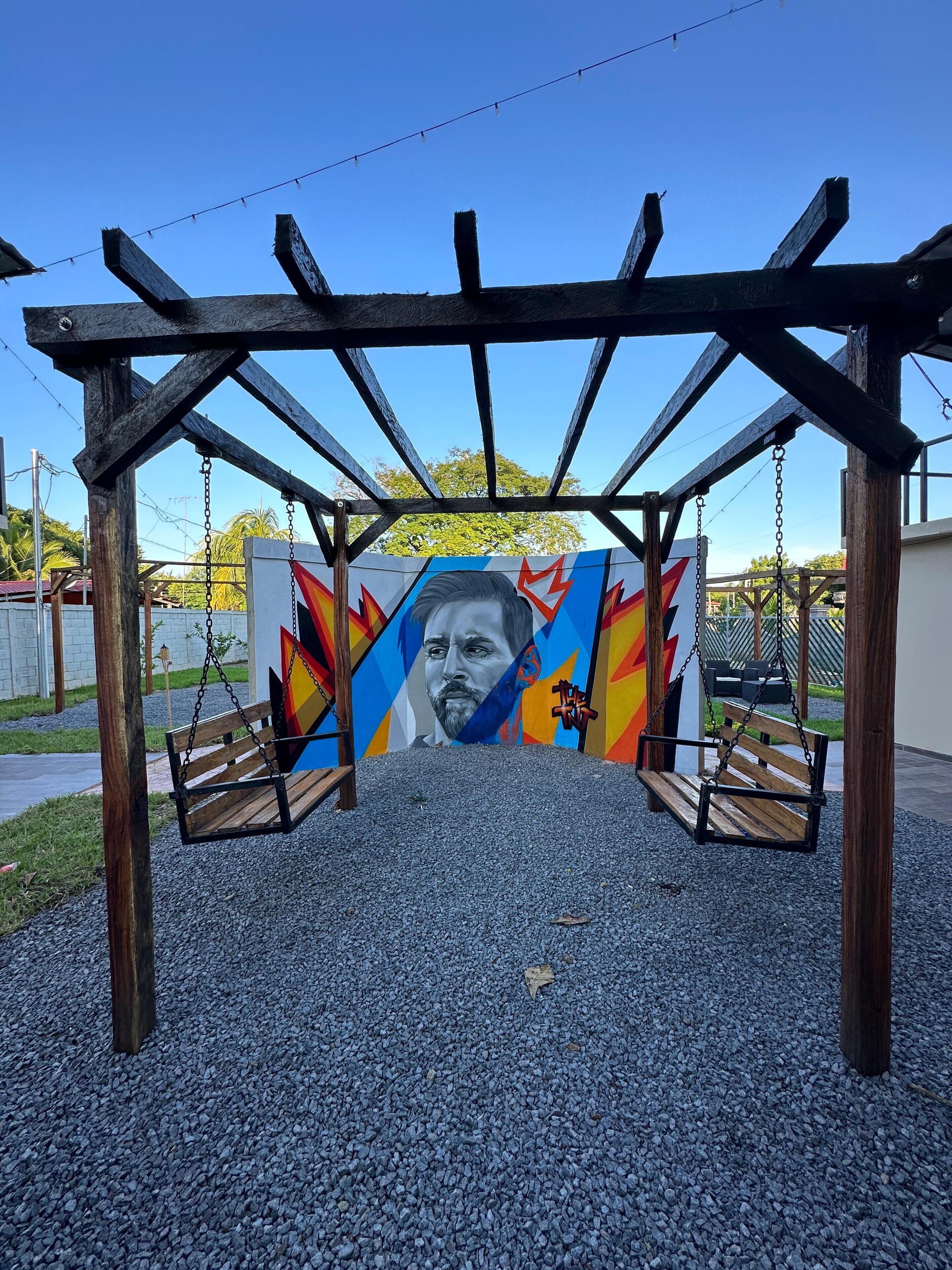 Un tobogan de fusta amb un mural de colors al fons.